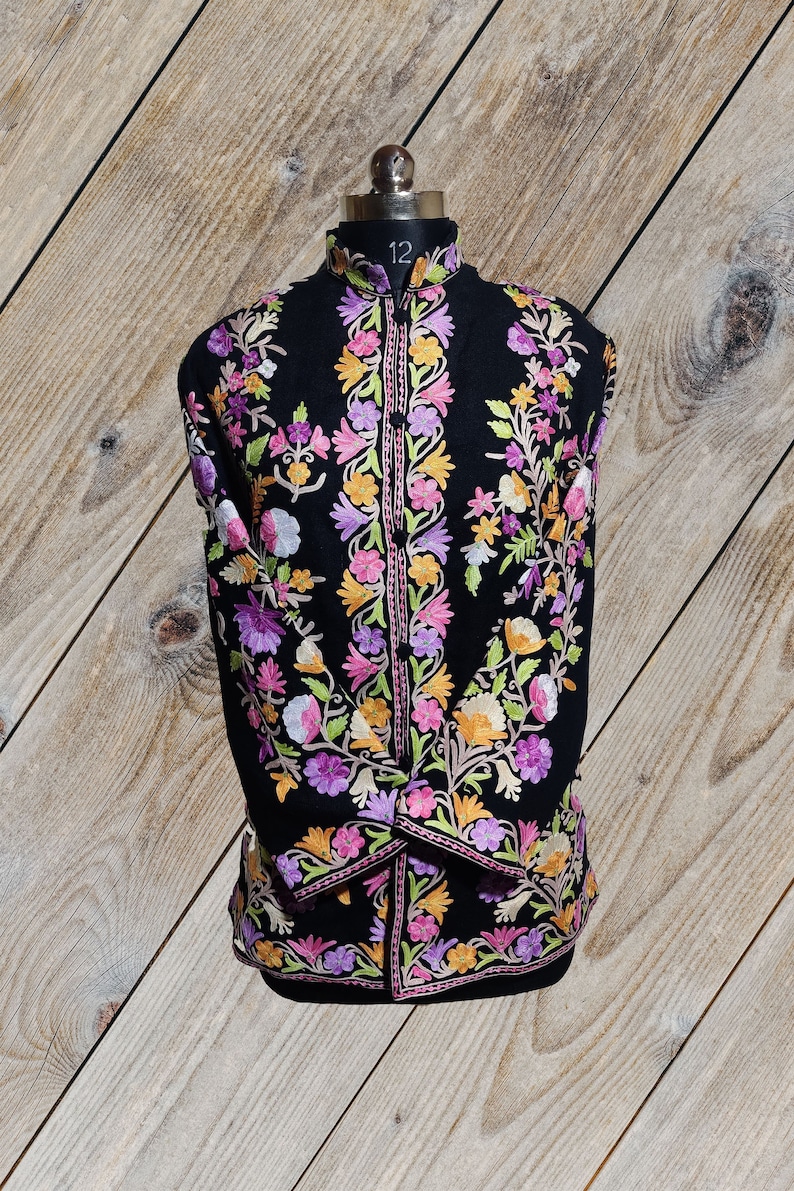 May include: A black embroidered jacket with a mandarin collar and floral embroidery in shades of pink, purple, yellow, and green.