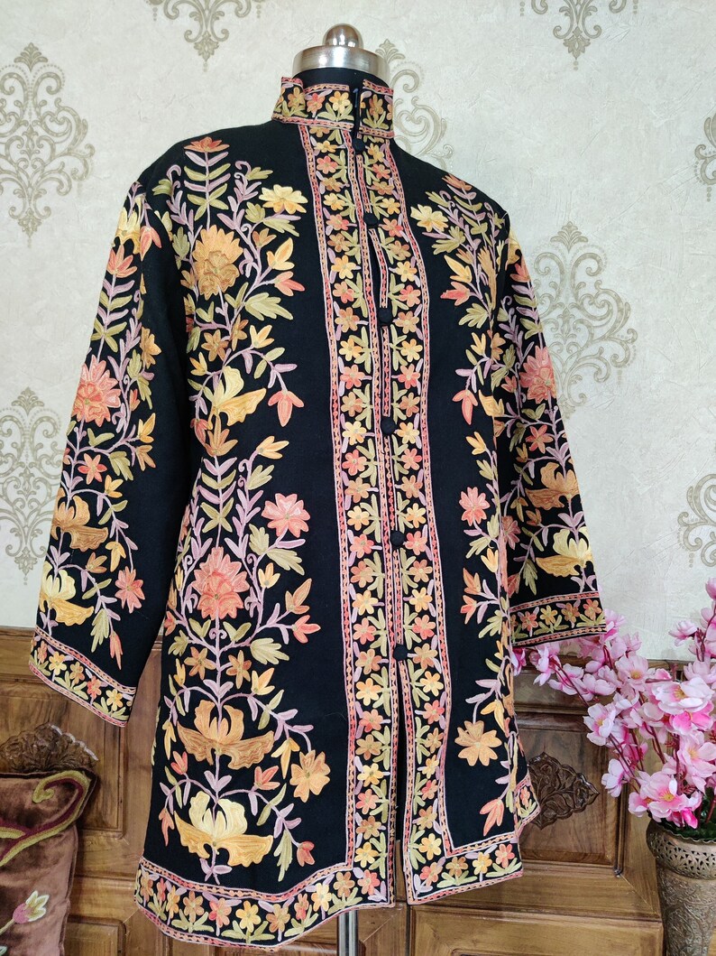 May include: A black embroidered jacket with a mandarin collar and floral patterns in shades of orange, pink, and yellow.