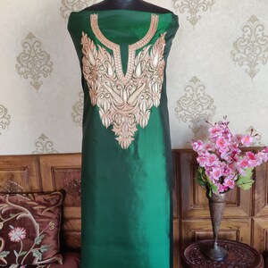 May include: A green silk kurta with gold embroidery on the neckline. The kurta is displayed on a mannequin.