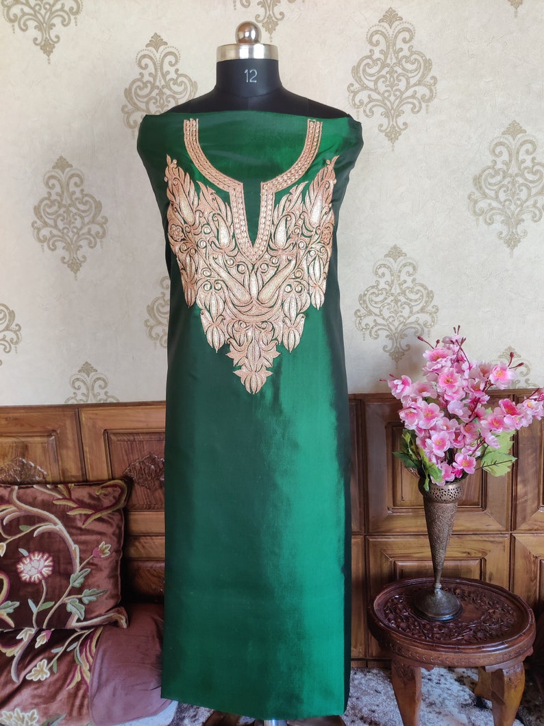 May include: A green silk kurta with gold embroidery on the neckline. The kurta is displayed on a mannequin.