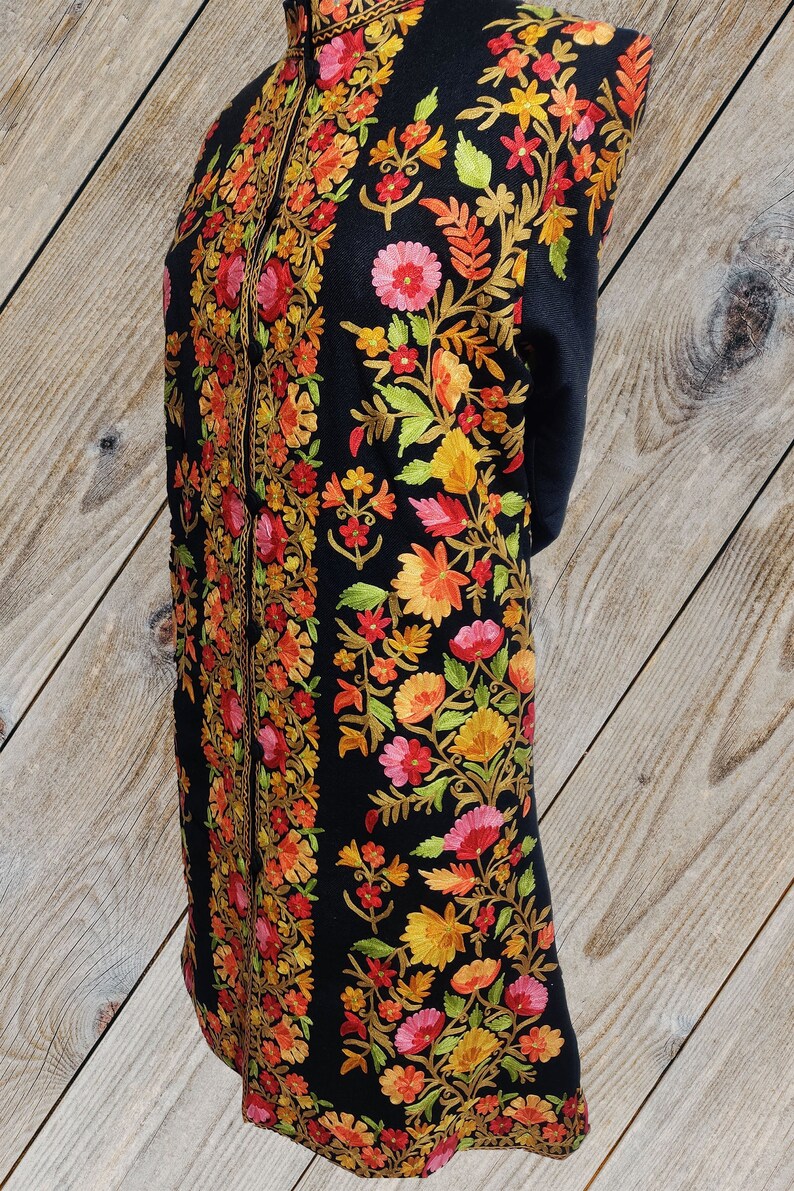 May include: A black long-sleeved shawl with intricate floral embroidery in shades of red, orange, yellow, and green.