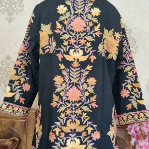 May include: A black embroidered jacket featuring a floral design in shades of orange, yellow, pink, and green. The jacket has a mandarin collar and long sleeves.