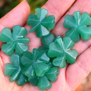 以下が含まれることがあります： 緑色の翡翠でできた四つ葉のクローバーのチャームが7つあります。チャームは翡翠から彫られており、滑らかで磨かれた仕上げになっています。