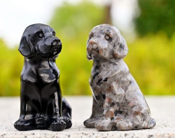 May include: Two small dog figurines, one black and one gray with black speckles. Both are sitting with their heads turned to the side.