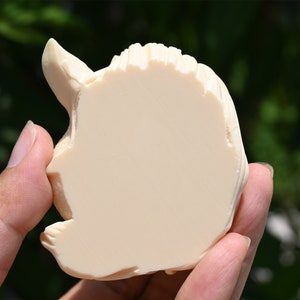 May include: A white ceramic sculpture of a unicorn head, with a detailed mane and horn.
