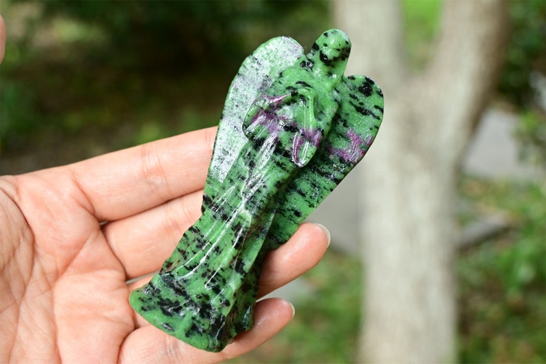 May include: Green, black and pink carved angel figurine made of green aventurine gemstone.