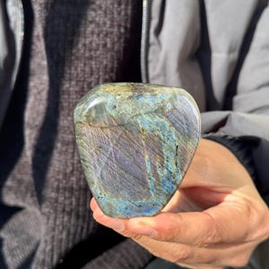 May include: A heart-shaped labradorite crystal with iridescent blue, green, and gold hues. The crystal is polished and smooth.