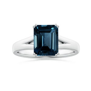 Könnte beinhalten: Ein silberner Ring mit einem blauen Smaragdschliff-Edelstein.