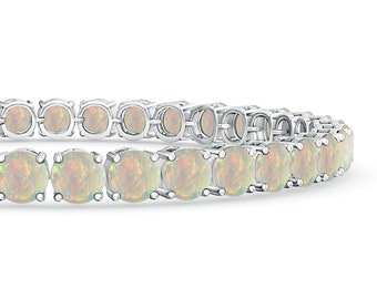 May include: A silver tennis bracelet with a row of white opal stones.