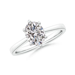 May include: A solitaire engagement ring with a large, oval-cut diamond set in a simple, polished silver band. The diamond is held in place by six prongs, showcasing its brilliance. The ring is set against a white background.