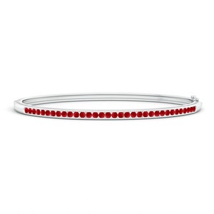 Pode incluir: Um bracelete de prata com uma fila de rubis vermelhos.