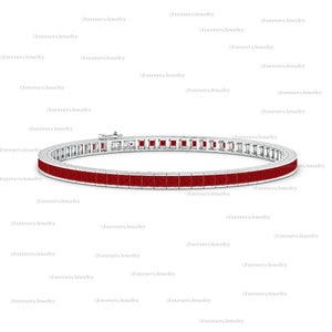 Könnte beinhalten: Ein silbernes Armband mit einer durchgehenden Reihe quadratischer, tiefroter Edelsteine. Das Armband hat einen sicheren Verschluss. Der Hintergrund ist weiß, mit dem Markennamen "Forevers Jewelry" wiederholt.