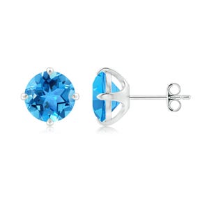 May include: A pair of stud earrings featuring round, faceted, bright blue gemstones set in a silver metal. The gemstones have a star-like pattern. The earrings are displayed on a white background.