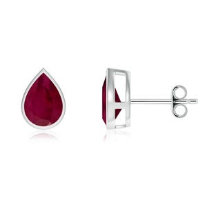 May include: A pair of silver teardrop earrings with red ruby gemstones.