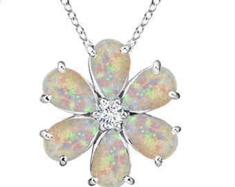 May include: A silver chain necklace with a white opal flower pendant. The flower has six petals and a small clear crystal in the center.