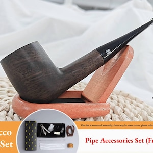 Może przedstawiać: Ciemna, drewniana fajka do tytoniu z czarnym ustnikiem, umieszczona na drewnianym stojaku. Zestaw zawiera etui i akcesoria. Tekst na zdjęciu to "Tobacco Pipe Set" i "Pipe Accessories Set (Freebies)".