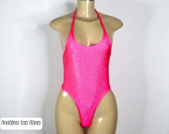 Könnte beinhalten: Ein leuchtend pinkfarbener Neckholder-Body mit kleinen, glitzernden Verzierungen. Das hoch geschnittene Design und der offene Rücken erzeugen eine schlanke Silhouette. Der Text "Fashion Lux Shop" ist unten links sichtbar.