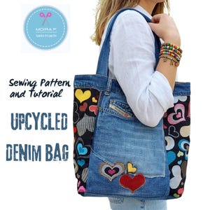 Può includere: Borsa tote in denim riciclato con un design patchwork. La borsa presenta una base in denim con applicazioni a forma di cuore e dettagli in tessuto fantasia. Il testo "UPCYCLED DENIM BAG" è visibile. La borsa ha manici in denim e una tasca.