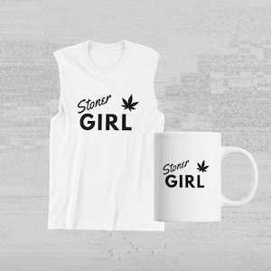 Peut inclure: Un t-shirt blanc sans manches et une tasse blanche avec du texte noir qui dit "Stoner Girl" et un graphique de feuille de marijuana noire.