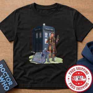 May include: Black t-shirt featuring a graphic of the Doctor Who character with the TARDIS and K-9. The Doctor is wearing a long coat and scarf. The TARDIS is a blue police box. The graphic is set on a green grassy area.