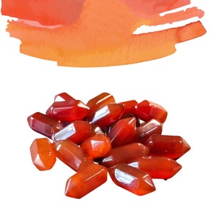 May include: A pile of carnelian crystal points in various sizes and shapes. The crystals are a deep reddish-orange color and have a smooth, polished finish.