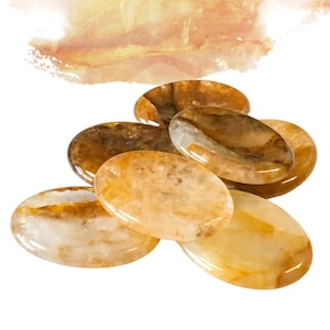 May include: A collection of six oval-shaped, polished citrine stones. The stones are a light yellow colour with brown and white inclusions. The stones are smooth and have a glossy finish.