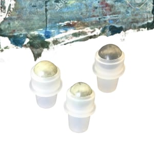 May include: Three small, clear plastic roll-on bottles with a light-coloured, spherical top. The tops appear to be made of a stone-like material. The bottles are arranged in a triangular formation against a white background.
