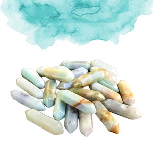 May include: A pile of green, brown, and white polished agate crystal points. The points are smooth and have a natural, organic look.