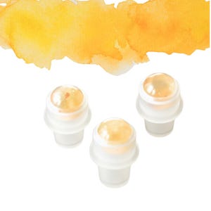 May include: Three clear glass roll-on bottles with a golden liquid. The bottles have a white base and a spherical top. A yellow and orange watercolour wash is in the background.