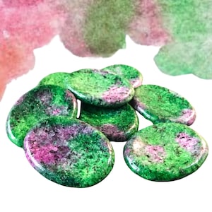May include: A group of oval-shaped green and pink stones with a speckled pattern. The stones are smooth and polished.