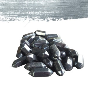 May include: A pile of black, pointed, crystal-like stones. The stones are smooth and have a metallic sheen.