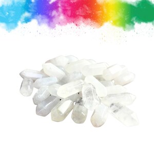 Puede incluir: Un montón de puntas de cristal blanco, también conocidas como puntas de cuarzo claro. Las puntas son lisas y pulidas, con una ligera translucencia.