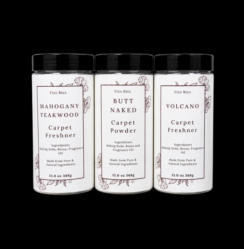 May include: Three cylindrical containers with black lids, each featuring a white label with floral illustrations. The labels are printed with the text Fizz Bizz, product names Mahogany Teakwood, Butt Naked, and Volcano, and 13.0 oz 368g weight.