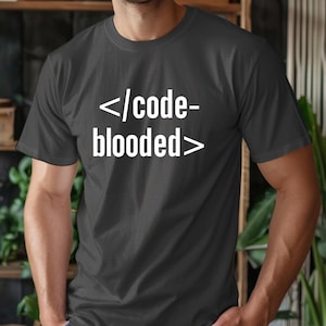 May include: A dark gray t-shirt with white text that reads "<code>-blooded>"