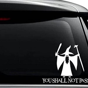 May include: White vinyl decal of Gandalf the Grey from the Lord of the Rings, holding a staff and sword, with the text "You Shall Not Pass!" below.