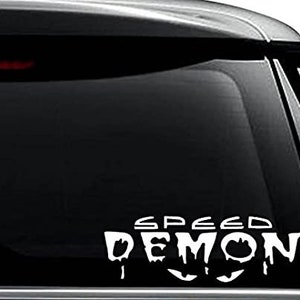 May include: White vinyl decal sticker with the words "Speed Demon" in a dripping font style. The sticker is on the back window of a black car.
