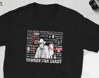 Può includere: T-shirt nera con una stampa grafica bianca del cantautore Townes Van Zandt. La grafica include una foto di Van Zandt e un elenco dei suoi titoli di canzoni, tra cui "Poncho and Lefty", "Loretta", "If I Needed You", "Two Girls" e "Sweetheart of the Rodeo".