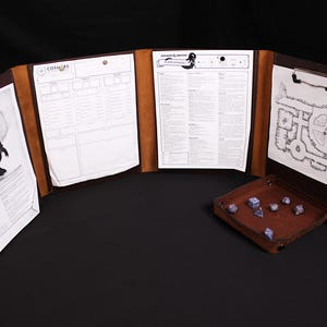 Könnte beinhalten: Ein vierteiliger Spielleiterschirm aus braunem Leder mit Metallclips, an denen Charakterbögen, eine Monsterillustration und eine Dungeon-Karte befestigt sind. Ein passendes quadratisches Würfeltablett aus braunem Leder enthält blaue Würfel.