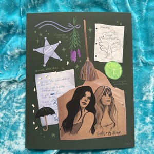 May include: Dark green art print featuring a star, lavender, a broom, a tree, a lime, and two women. Text includes "Lavender for luck", "AMAS VERITAS", and song lyrics. The print is signed "TAT".