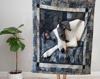 Könnte beinhalten: Ein schwarz-weißer Hund mit einer blauen und weißen gemusterten Steppdecke dahinter. Der Hund liegt mit dem Kopf auf seinen Pfoten. Die Steppdecke hat einen Rand aus schwarzen und weißen Quadraten.
