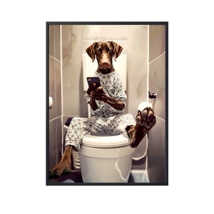 May include: A brown dog wearing pajamas sits on a white toilet in a bathroom, looking at a smartphone.