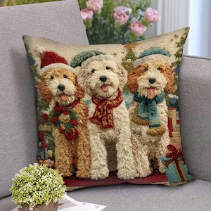 May include: A decorative square pillow featuring three dogs in festive attire. The dogs are wearing Santa hats, scarves, and a wreath. The pillow has a textured appearance and is set against a backdrop of Christmas-themed elements.