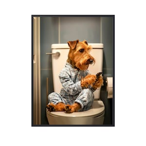 Könnte beinhalten: Ein brauner und tanner Hund in blau-weißem Pyjama sitzt auf einem weißen Toilettensitz und schaut auf ein Smartphone in seinen Pfoten.