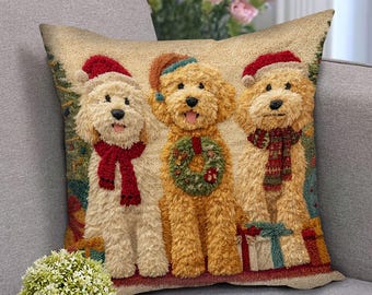 May include: A decorative square pillow featuring three golden doodle dogs dressed for Christmas. Each dog wears a Santa hat and a scarf or wreath. The background includes Christmas trees and wrapped gifts, creating a festive holiday theme.