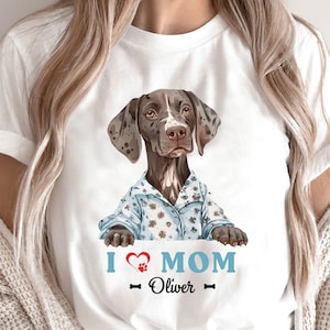 Pode incluir: Camiseta branca com um cão Braco Alemão de Pelo Curto marrom e branco vestindo uma camisa de flores azul e branca. O cão está olhando para a câmera. O texto "I love MOM - Oliver -" está impresso abaixo do cão.