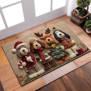 Op de afbeelding: Een rechthoekige beige deurmat met vier cartoonhonden in kerstoutfits. Eén hond draagt een kerstmuts en houdt een zuurstok vast. Andere honden zijn verkleed als rendier, kerstboom en winteroutfit.