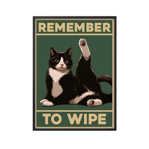 Puede incluir: Un póster de estilo vintage con un gato blanco y negro con una pata levantada. El póster tiene el texto "REMEMBER TO WIPE" en un recuadro amarillo.