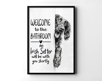 Może przedstawiać: Czarna oprawiona grafika ścienna z napisem "WELCOME to the BATHROOM - an Irish Setter will be with you shortly." Czarno-biała ilustracja psa Irish Setter wyglądającego zza białego tła.
