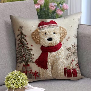 May include: Square decorative pillow with a festive Christmas theme. The pillow features an embroidered image of a dog wearing a red scarf and hat. A Christmas tree and wrapped gifts are also embroidered on the pillow.