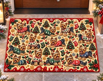 Può includere: Uno zerbino rettangolare con un motivo ripetuto di Yorkshire Terrier che indossano maglioni natalizi, intervallato da illustrazioni di alberi di Natale, calze, agrifoglio e fiocchi di neve su sfondo crema con bordo rosso.